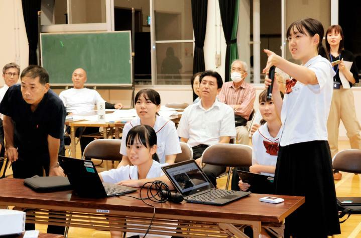 危険な通学路への街路灯設置の必要性を住民に説明する丹原西中生ら