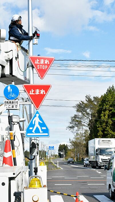 赤色の回転灯を取り付ける作業員＝28日、六戸町