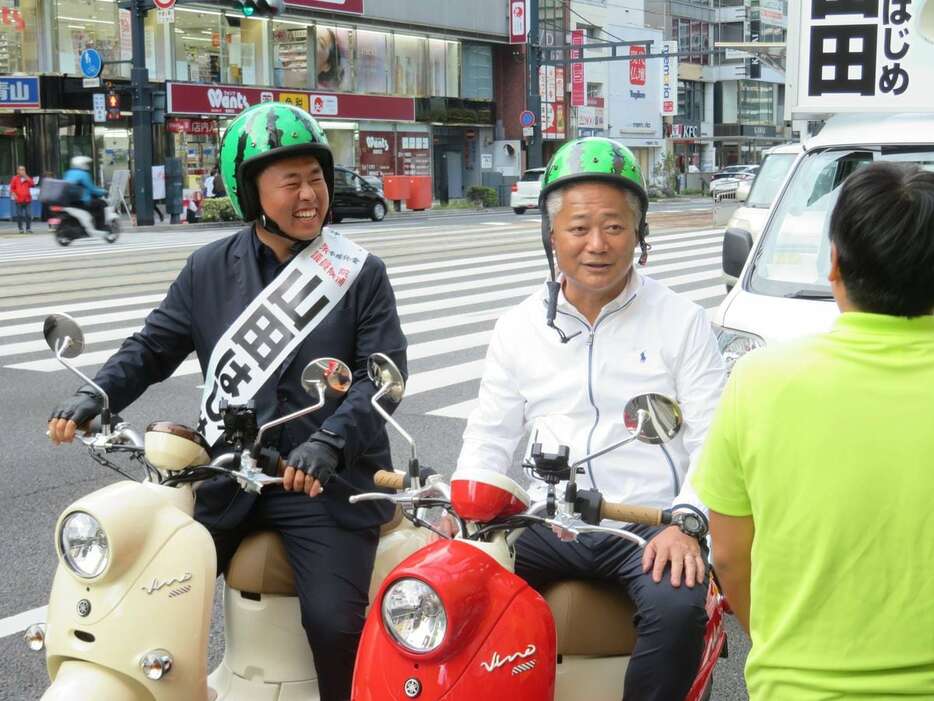 維新の馬場伸幸代表とともにスイカ柄のヘルメットをかぶり、ミニバイクにまたがる山田肇氏＝10月23日、広島市中区（矢田幸己撮影）