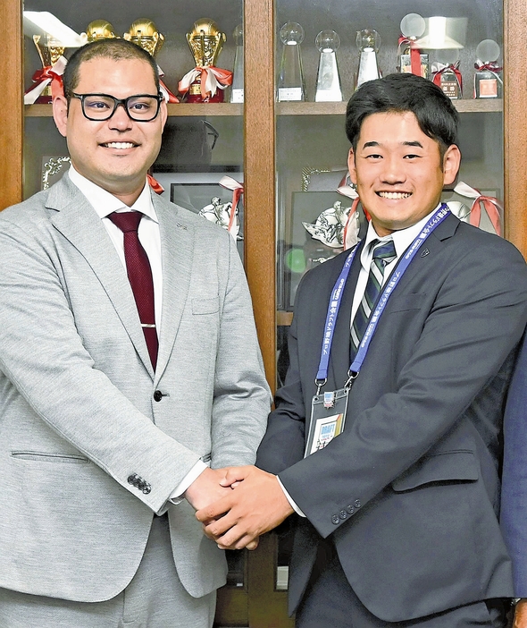 楽天の岩見さん（左）と握手する徳山投手（岡山県和気町で）