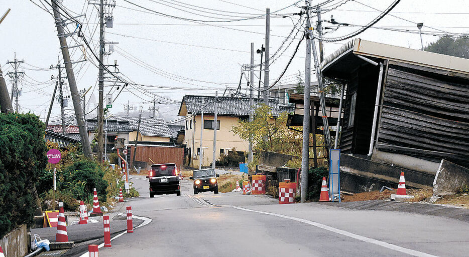 液状化の影響で道路が波打ち、建物が傾いたままの内灘町西荒屋地区