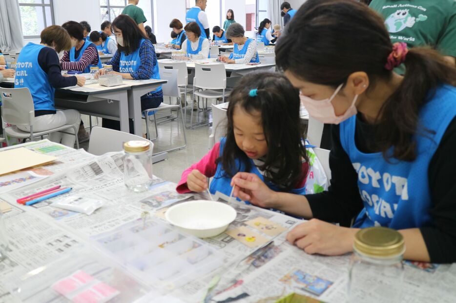 ロスフラワーの押し花でマイジャー用のタグを作る親子（京都市上京区・同志社大）