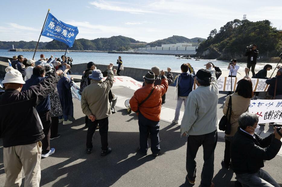 東北電力女川原発（奥）の再稼働に抗議する人たち＝29日午後、宮城県女川町