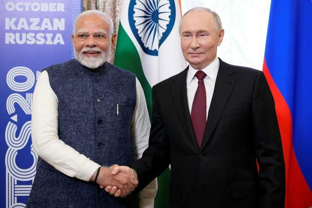 ロシア西部カザンで2024年10月22日、首脳会談の際に握手するプーチン大統領（右）とインドのモディ首相。新興国グループBRICSの首脳会議が開かれる前に、両者は会談に臨んだ=ロイター