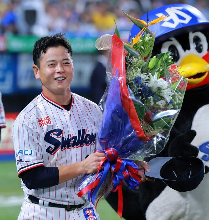 3日の引退セレモニーで花束を受け取り笑顔を見せるヤクルト・山崎晃大朗＝神宮球場