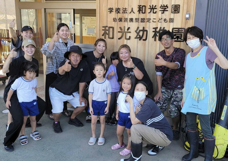 新米と水を届けた浜さんと水上バイク仲間。園児たちと記念撮影。