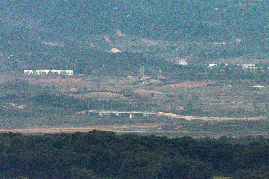 韓国軍合同参謀本部は１５日、北朝鮮が南北道路の一部を爆破したと明らかにした。写真は韓国の坡州市から１４日に撮影された南北を隔てる非武装地帯（DMZ）北部の京義線道路にある構造物の近くに積み上げられた土の山。聯合ニュース（２０２４年　ロイター）