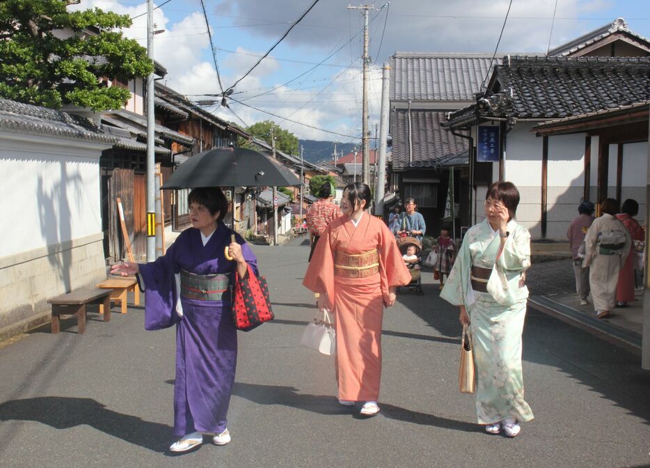 秋晴れの中、イベントの来場者でにぎわう「ちりめん街道」でのそぞろ歩きを楽しむ着物姿の女性たち（与謝野町加悦）