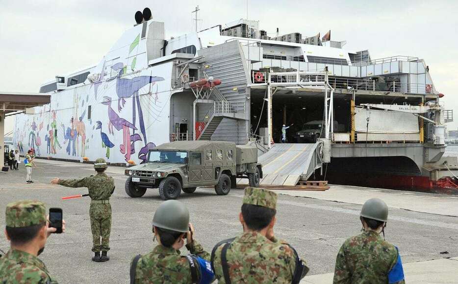 横浜ノース・ドックに入港した民間船舶「ナッチャンWorld」から降ろされる自衛隊車両＝17日午後、横浜市（桐原正道撮影）