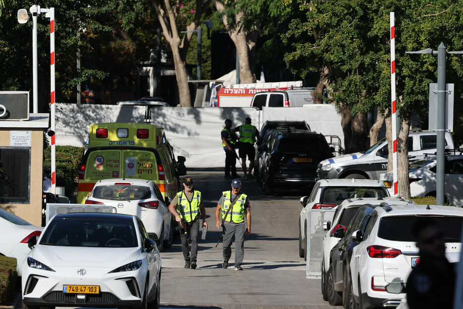 １９日、イスラエル中部カイサリアで、ネタニヤフ首相の私邸に通じる道路に展開する治安要員や救急車（ＡＦＰ時事）