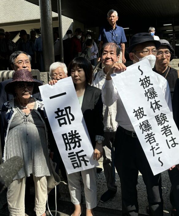 長崎地裁前で判決を報告する原告団長の岩永千代子さん（前列左）ほか関係者。（撮影／橋場紀子）