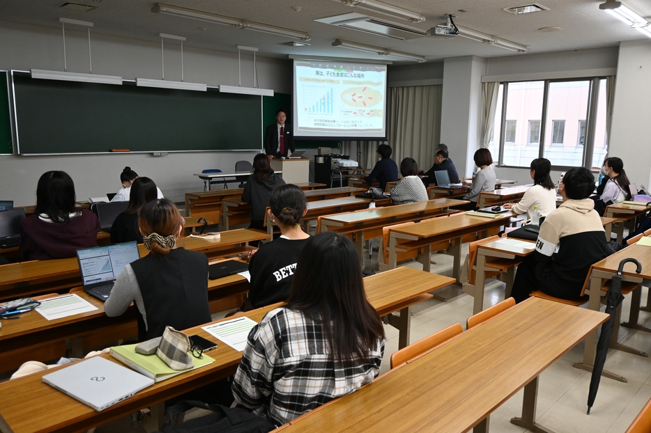 【味の素の田中さんの講義を聞く学生ら＝鈴鹿市郡山町の鈴鹿大学短期大学部で】