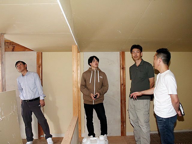 再生する納屋を見学しながらアドバイスを受ける山田さん（右３人目）