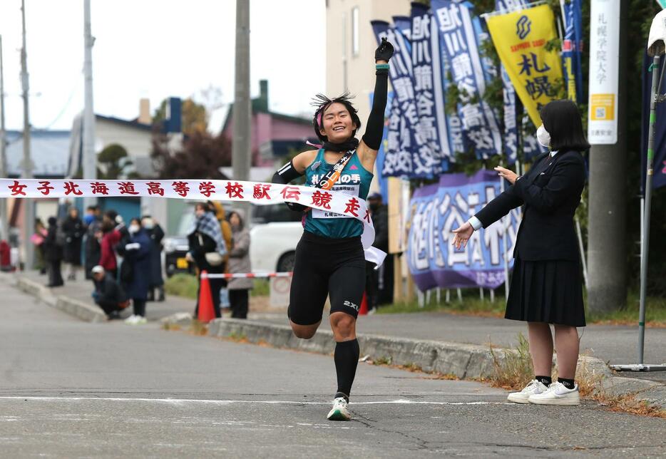 女子で初出場初優勝した札幌山の手のアンカー渡辺は左手を挙げて笑顔でゴール（撮影・中島洋尚）