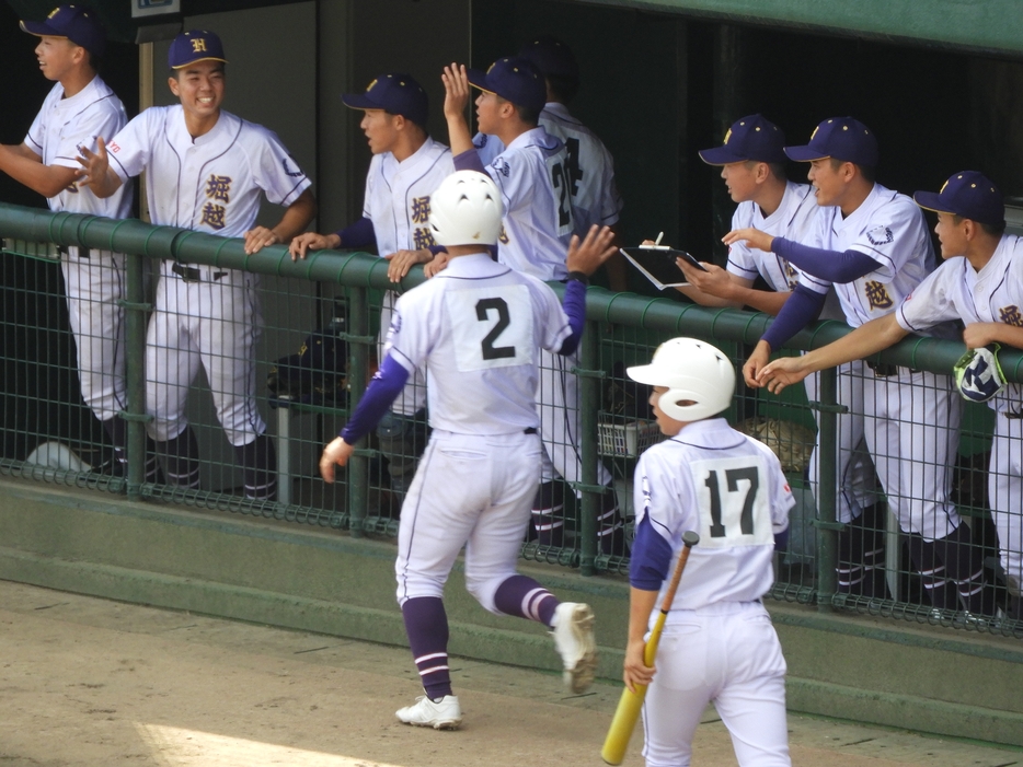 ホームインした長野を迎える堀越ベンチ