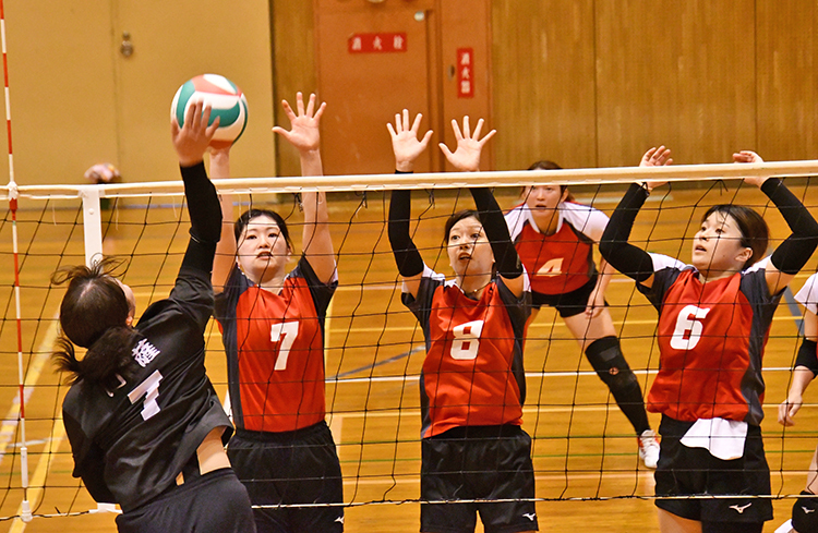 女子予選リンク　大島―川薩戦。　川薩のスパイクをブロックする大島の（左から）東、藤井、明石（19日、奄美市笠利町の太陽が丘総合体育館）