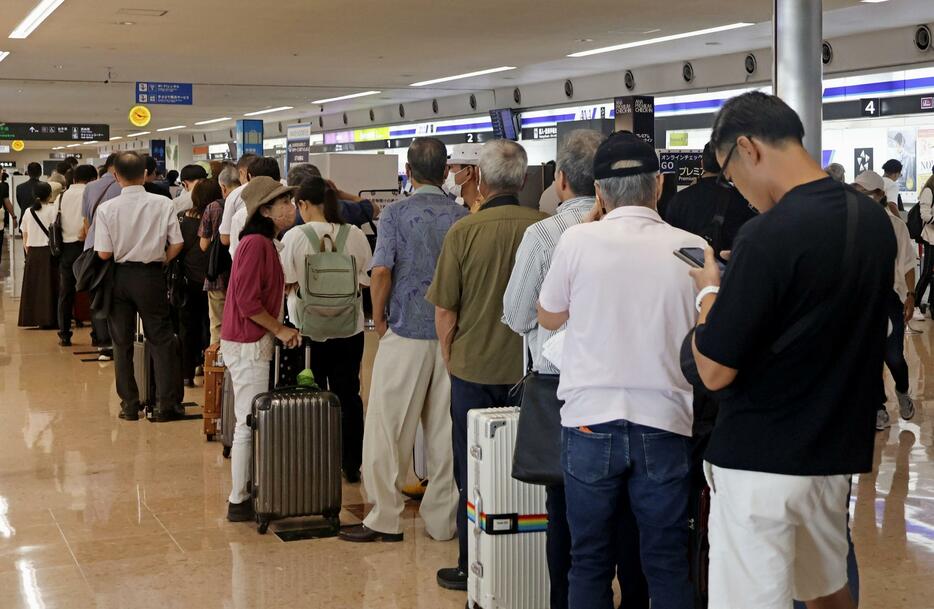 宮崎空港の滑走路が閉鎖され、航空会社の窓口に並ぶ大勢の人たち＝2日午前、宮崎市