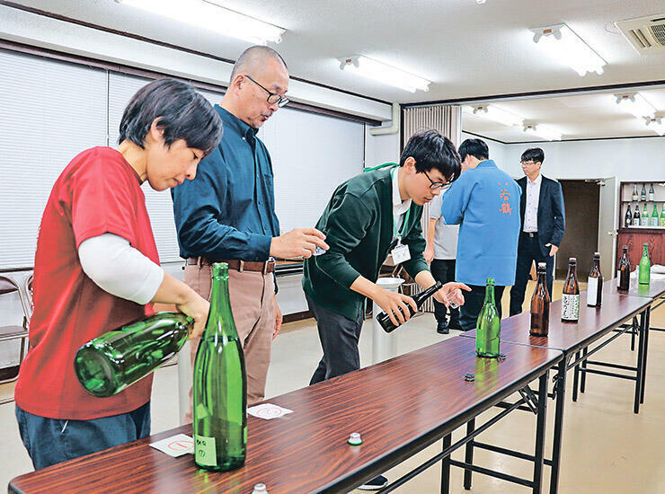 試飲しながら味や香りなどを審査する関係者=県酒造組合