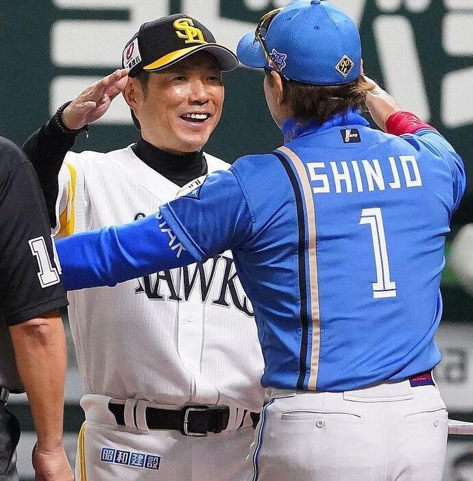 5月の対戦でメンバー表交換を終え、日本ハム・新庄監督（手前）と抱き合う小久保監督（撮影・西田忠信）