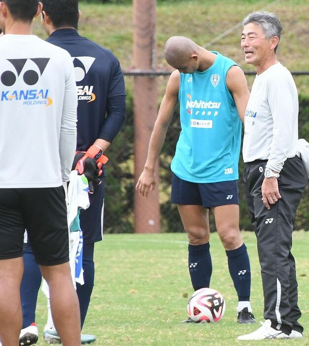 15日の練習後、円陣を組んだ選手たちに笑顔を見せるJ1福岡・長谷部監督（右）