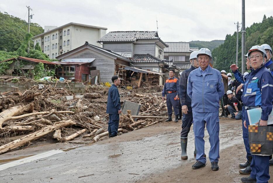 石川県輪島市を訪れ、記録的豪雨で家屋が流された現場を視察する石破首相（手前左）＝5日午前（代表撮影）