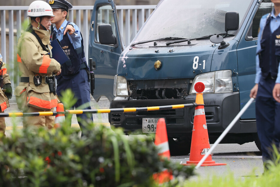 火炎瓶のようなものが投げ込まれ、炎上したとみられる自民党本部前の警察車両＝１９日午前、東京・永田町