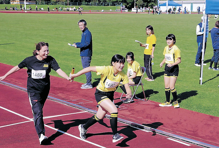 バトンをつなぐＴ．ｋｉｄｓ津沢ＪＶＣのメンバー＝小矢部市の小矢部陸上競技場