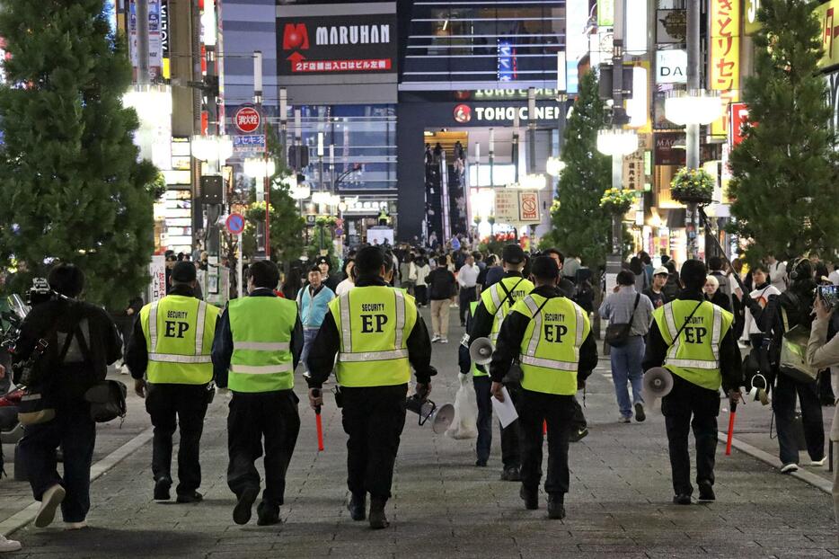 路上飲酒の禁止を呼びかける警備員ら＝31日午後、東京・歌舞伎町