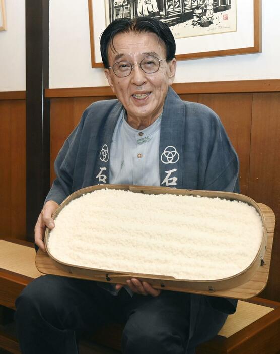 種こうじと蒸したコメを混ぜて仕込んだ生こうじを手にする「石黒種麹店」4代目当主の石黒八郎さん＝9月、富山県南砺市