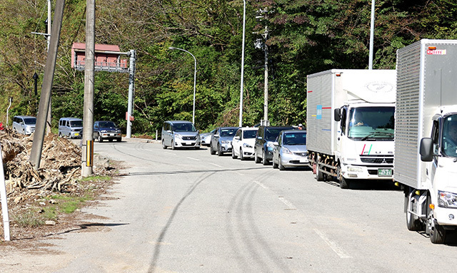 国道344号の全面通行止めの解除を待つトラックや乗用車＝酒田市北青沢