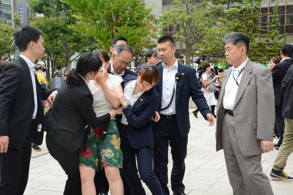 「増税反対」と叫び、制止される女性（左から3人目）＝札幌市中央区で2019年7月15日、岸川弘明撮影