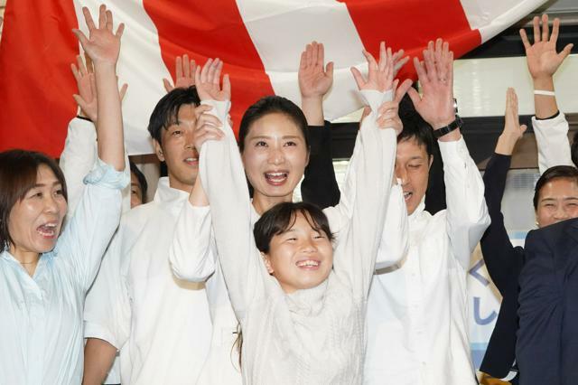 当選確実の知らせを受け、支援者や家族と万歳する日野紗里亜氏（中央）=2024年10月27日午後8時7分、愛知県東郷町、小玉重隆撮影