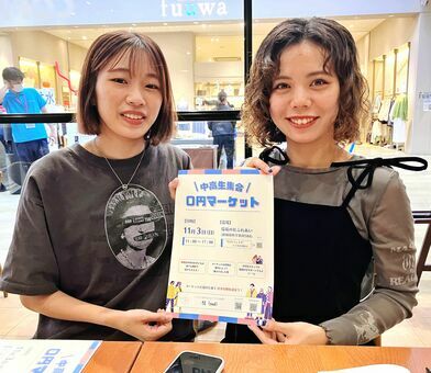 「０円マーケット」への来場を呼びかける「子ども服屋　彗」メンバーの饒平名凜さん（右）と當真あかりさん＝１１日、南風原町内