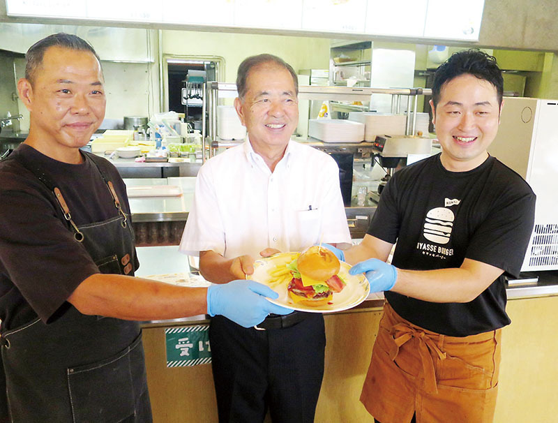 キヤッセのバーガーをお披露目する（左から）渡辺貴広さん、河田晃明市長、百瀬亨店長＝羽生市三田ケ谷のキヤッセ羽生