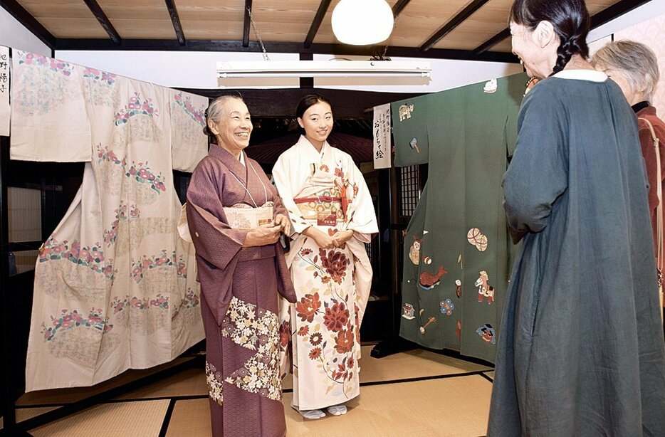 教え子と会場に立ち、来場者へ作品解説する池野さん（左）