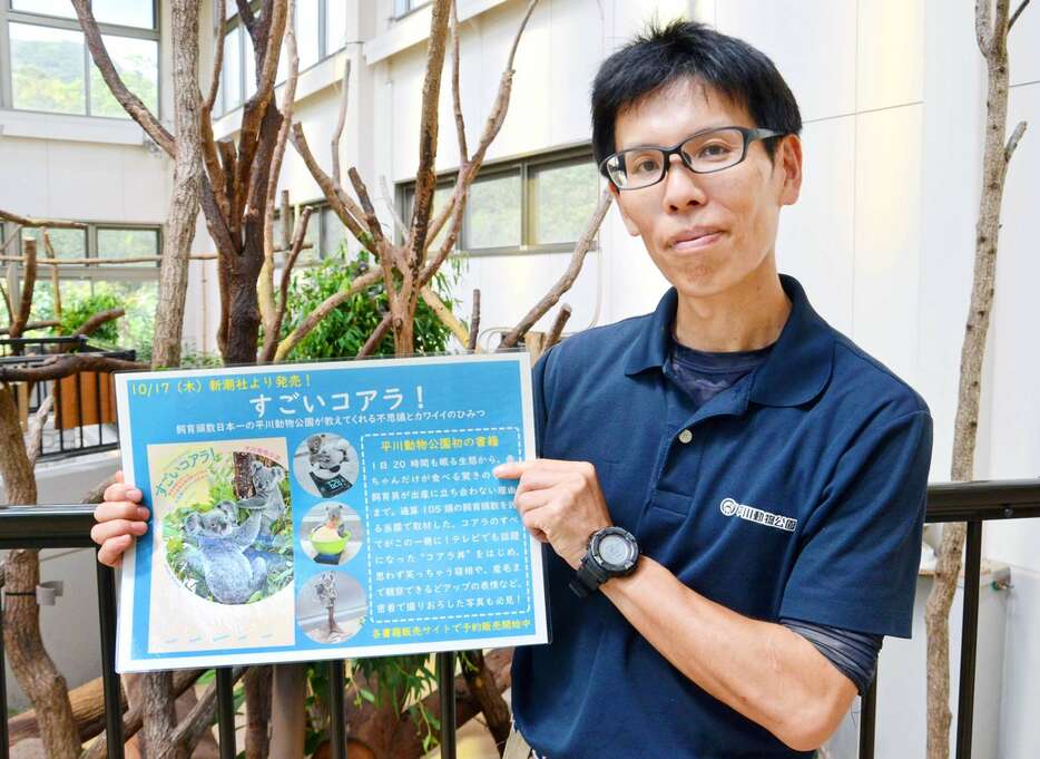 初のコアラ本を紹介する落合晋作係長＝鹿児島市の平川動物公園