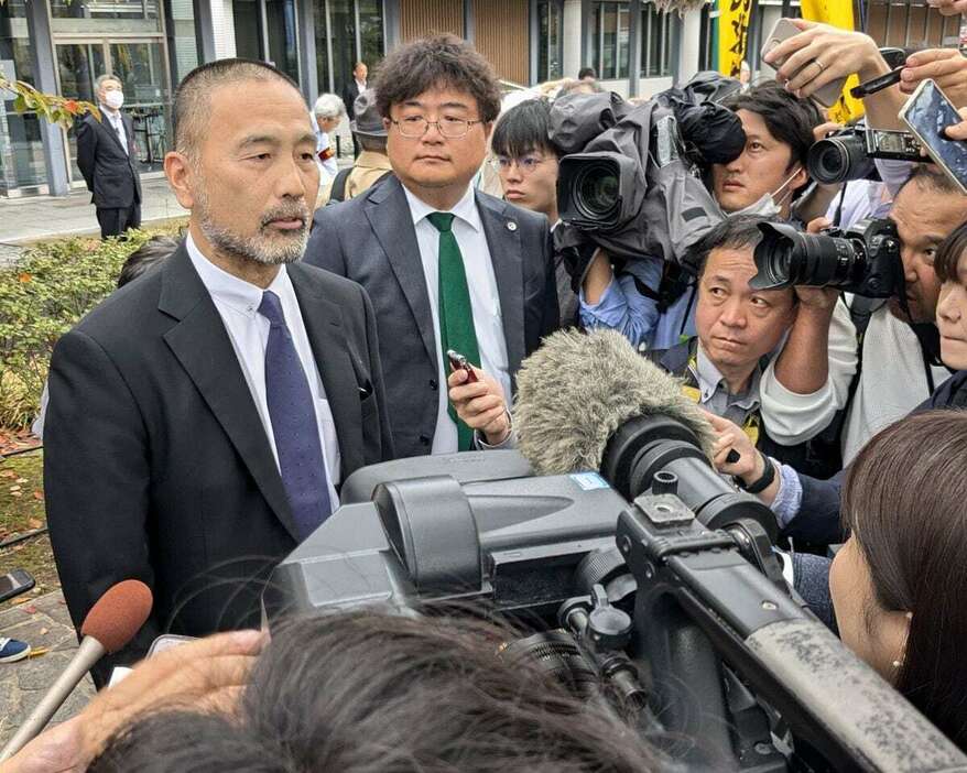 名古屋高裁金沢支部の決定を受け、同支部前で取材に応じる前川彰司さん（左）＝23日午前、金沢市（西山瑞穂撮影）