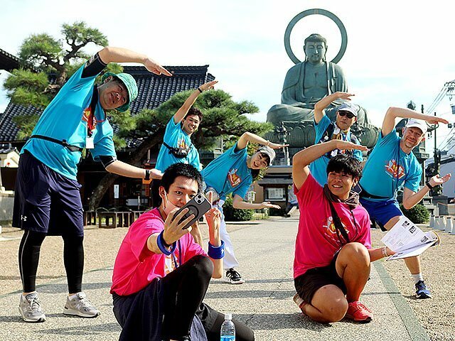 高岡大仏の前で写真を撮る参加者＝高岡市大手町