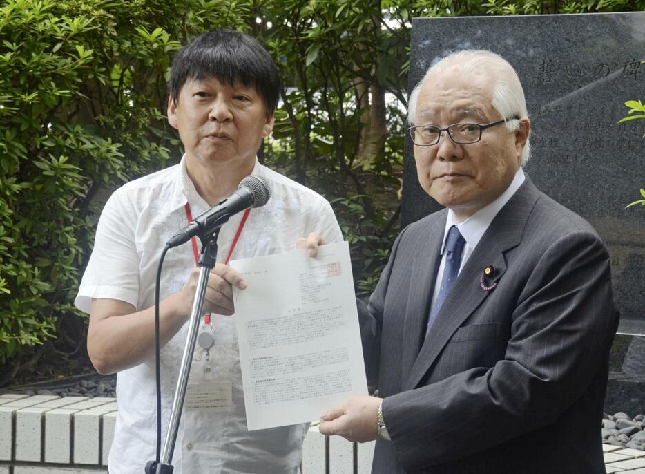 武見厚労相（当時・右）に要望書を手渡す薬被連の花井十伍代表世話人＝8月、厚労省