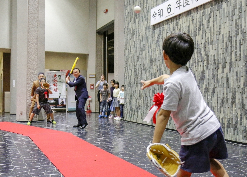 特別展にちなみ始球式をする西馬城小の児童ら