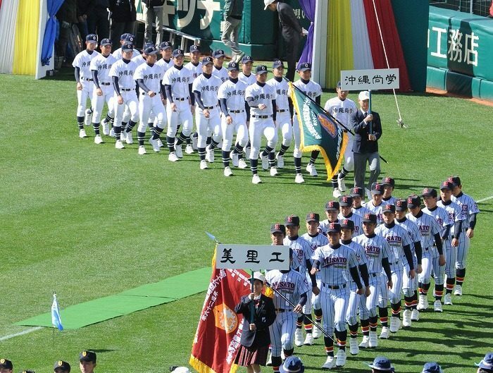 2014年の選抜高校野球大会開会式で、堂々と行進する美里工業（手前）と沖縄尚学ナイン＝兵庫県西宮市の阪神甲子園球場