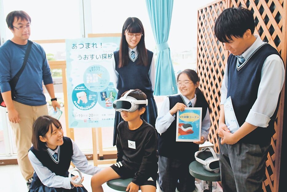 ＶＲを体験する親子に説明する生徒