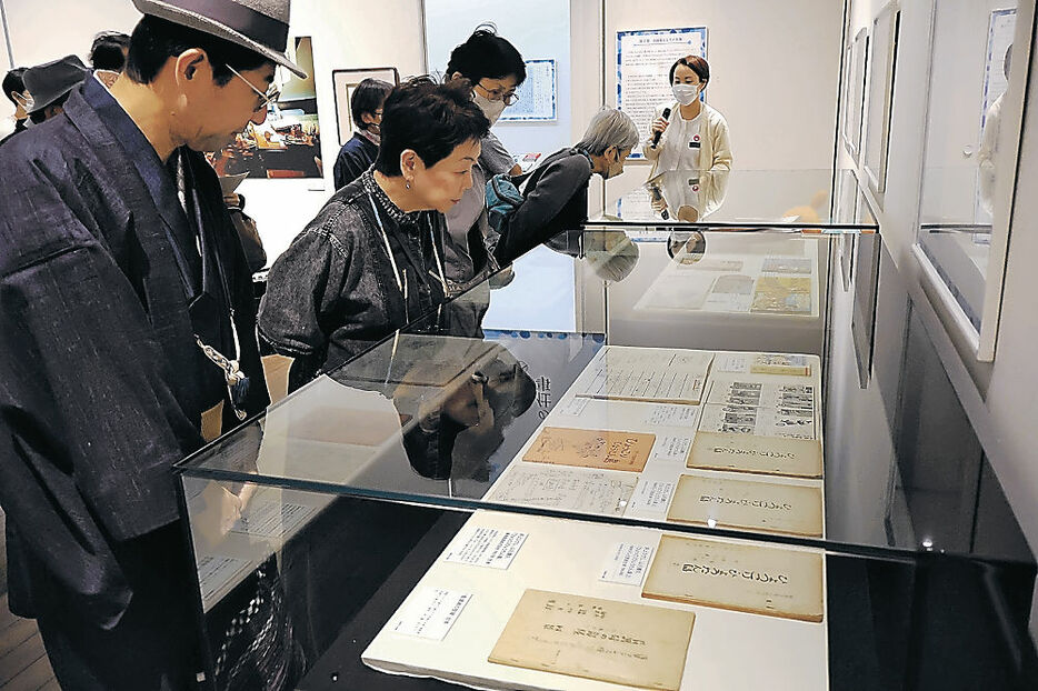 ひょっこりひょうたん島の台本に見入る来場者＝富山市の高志の国文学館