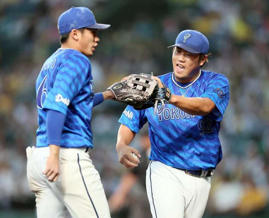 八回、好守の森敬斗（左）とタッチを交わすDeNA・堀岡隼人＝甲子園球場（撮影・荒木孝雄）