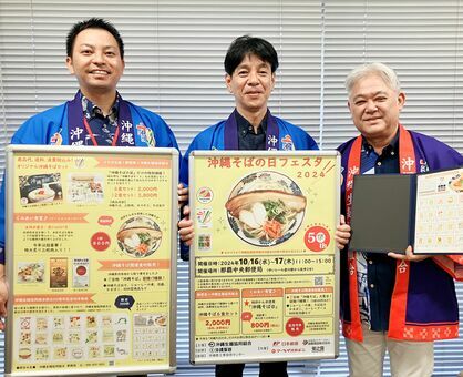 沖縄そばの日フェスタをＰＲする（右から）沖縄生麺協同組合の伊波興健理事長、日本郵便沖縄支社の西平勉室長、屋比久賢治係長＝１０日、沖縄タイムス社