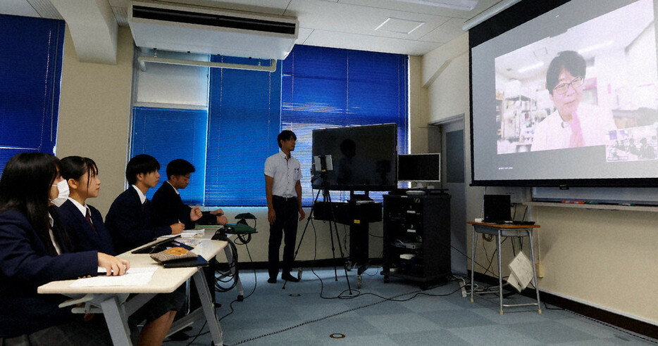 朝来市内で捕獲したメダカについて、東京大大学院の尾田正二准教授（右スクリーン）から教わる和田山高校の生徒ら＝兵庫県朝来市で２０２４年１０月４日午前１０時４７分、幸長由子撮影