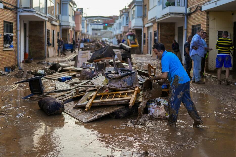 30日、スペインで発生した水害で、被害を受けた自宅の片付けをする男性（AP＝共同）