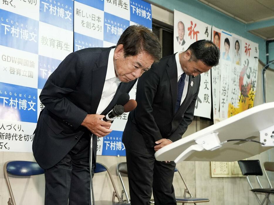 東京11区で落選が決まり、支持者らに頭を下げる下村博文氏（左）＝27日夜、東京都板橋区