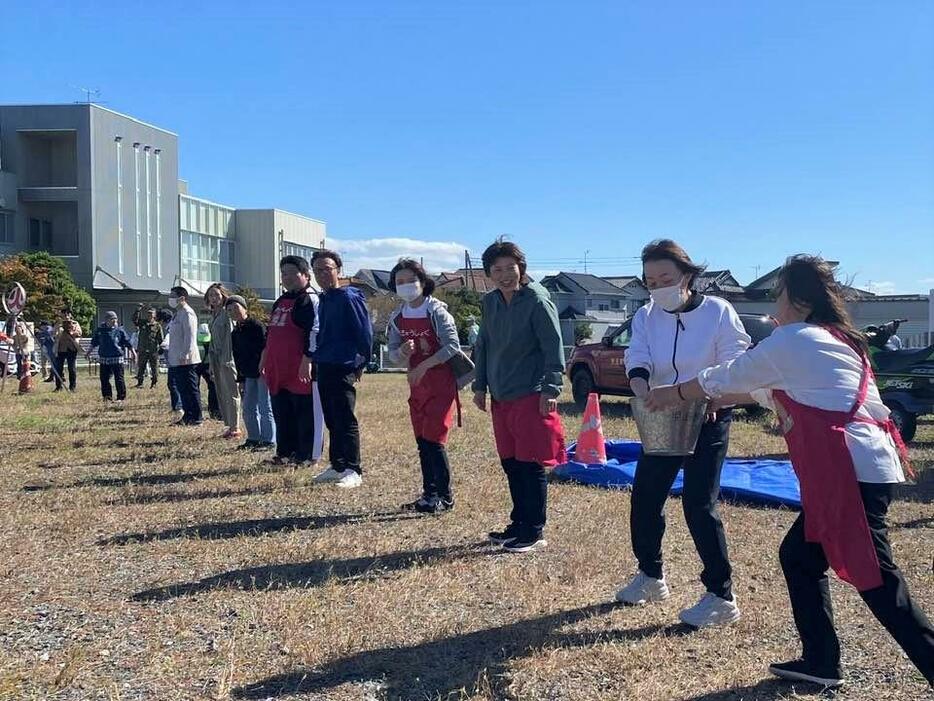 バケツリレーによる消火訓練に参加する地域住民と本庄上里学校給食センター職員ら