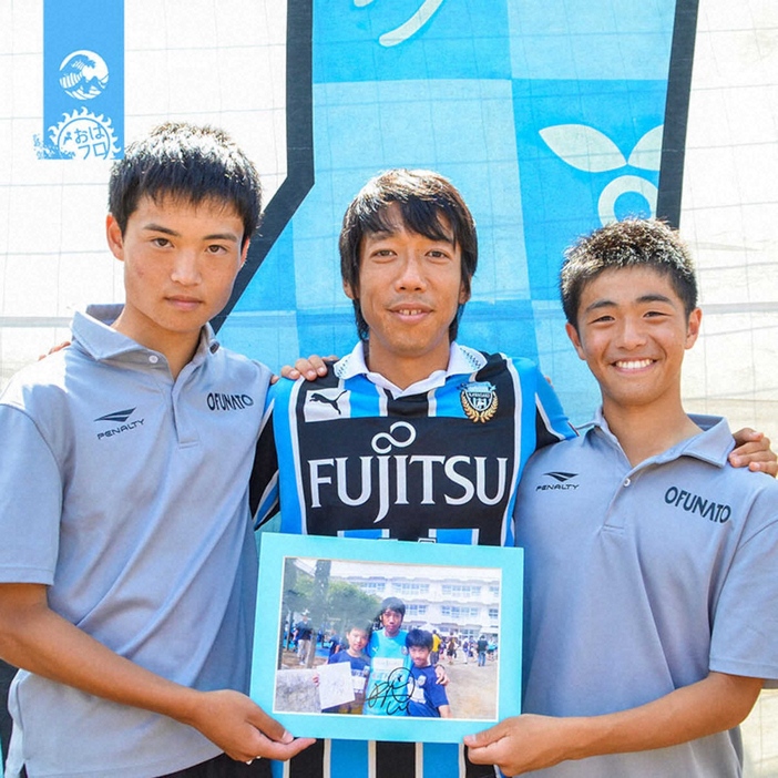 高校2年時のサッカー教室で中村憲剛さん（中央）と記念撮影をする菅野さん（右）